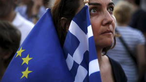 Một người dân cầm cờ của Liên hiệp châu Âu (EU) và Hy Lạp trong một cuộc tuần hành trước tòa nhà Quốc hội Hy Lạp, tại Thủ đô Athens, Hy Lạp, ngày 9-7-2015. (Ảnh: Reuters)