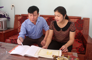 Vợ chồng chị Vì Thị Oanh, xóm Mỏ, xã Chiềng Châu (Mai Châu) trao đổi về kết quả học tập của các con.