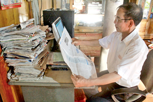 Ông Bùi Văn Mưng, người có uy tín  của xóm Bưng, xã Nhân Nghĩa (Lạc Sơn) nghiên cứu, tìm hiểu thông tin trên  báo Đảng bộ tỉnh.