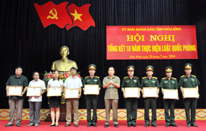 Đồng chí Nguyễn Văn Quang, Phó Bí thư Tỉnh uỷ, Chủ tịch UBND tỉnh trao Bằng khen cho các tập thể đã có thành tích xuất sắc trong 10 năm thực hiện Luật Quốc phòng.