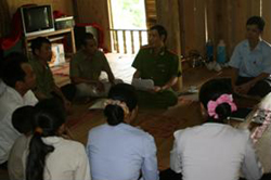 Thiếu tá Xa Tiến Thành (ngồi giữa)  trao đổi tình hình an ninh với bà con nhân dân