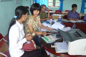 Cán bộ NHCSXH huyện Lạc Thủy hướng dẫn khách hàng  khu vực thị trấn Thanh Hà làm các thủ tục tín dụng.