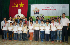 Lãnh đạo Công ty Prudential và huyện Yên Thủy trao học bổng cho các em học sinh nghèo hiếu học.