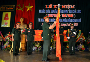 Thừa ủy quyền của Chủ tịch nước, đồng chí Trung tướng Phạm Quang Hợi gắn Huân chương Quân công hạng nhì lên lá cờ Quyết thắng của LLVT tỉnh.