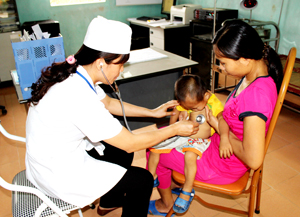 Cán bộ Trạm y tế xã Tân Vinh (Lương Sơn) khám, chữa bệnh cho trẻ em dưới 6 tuổi.