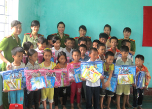 Cán bộ, chiến sỹ công an huyện Kim Bôi tặng quà các em học sinh nghèo vượt khó bản Dao Hang Lờm, xã Bình Sơn.