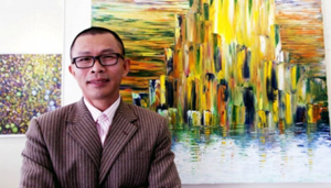 Họa sĩ Võ Trịnh Biện bên tác phẩm của mình.