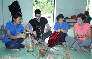 ĐV-TN phường Tân Hòa và thanh niên tình nguyện đến từ nước Canada trao đổi về ý nghĩa của đèn lồng truyền thống trong Tết Trung thu của Việt Nam.