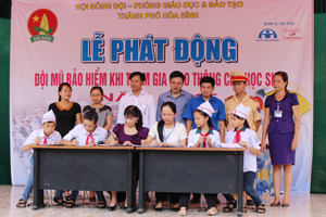 Ban đại diện cha mẹ học sinh, ban giám hiệu và các em học sinh trường THCS Sông Đà ký kết đội mũ bảo hiểm khi tham gia giao thông.