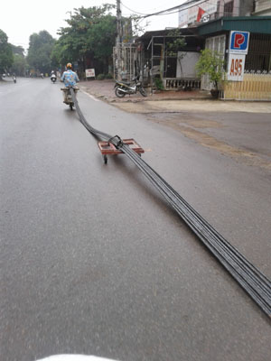 Xe máy chở kéo theo nhiều cây sắt, gây cản trở cho người tham gia giao thông.  ảnh chụp tại QL6, khu vực phường Chăm Mát (TP Hòa Bình). ảnh: VL

