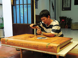 Nghệ nhân Trần Quốc Ẩn đang khắc bìa cuốn sách Hoa Lư thi tập .