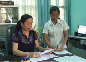 Chị Bùi Thị Xiềm (bên trái) trao đổi nghiệp vụ kiểm tra, giám sát với đồng nghiệp.