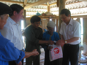 Thừa uỷ quyền Chủ tịch nước, đồng chí Bùi Văn Cửu, Phó Chủ tịch UBND tỉnh tặng quà cụ Bùi Thị Nhỏ.