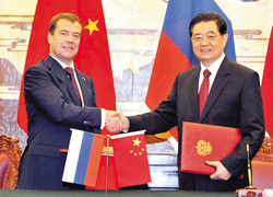 Tổng thống Nga Dmitry Medvedev (trái) và Chủ tịch Trung Quốc Hồ Cẩm Đào trao đổi các văn kiện hợp tác đã ký
