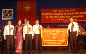 Đồng chí Nguyễn Văn Quang, Phó Bí thư Thường trực Tỉnh ủy trao bức trướng của Tỉnh ủy, HDND, UBND, UBMTTQ tỉnh cho Agribank Hoà Bình