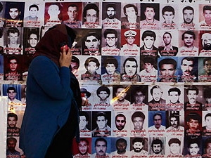 Một phụ nữ đi ngang qua những bức ảnh các nạn nhân bị thảm sát tại nhà tù Abu Salim.