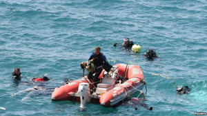 Thi thể một bé gái vừa được nhân viên cứu hộ đưa lên từ dưới nước.