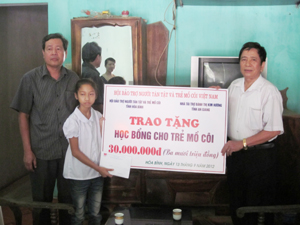 Thay mặt nhà tài trợ, Hội Bảo trợ NTT&TCM tỉnh, lãnh đạo UBND thành phố trao học bổng cho cháu Nguyễn Thị Hợp.