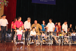 Đồng chí Trần Đăng Ninh, Phó Chủ tịch UBND tỉnh; lãnh đạo các sở, ban ngành tỉnh, thành phố và T.S Thích Giải Hiền, Hội trưởng Hội sự nghiệp từ thiện Minh Đức trao xe lăn cho trẻ em khuyết tật.