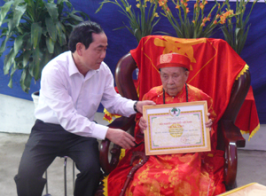 Đồng chí Nguyễn Văn Quang, Phó Bí thư Thường trực Tỉnh ủy, Chủ tịch HĐND tỉnh trao giấy mừng tho chi cụ Vũ Thị Bồng, 100 tuổi tiểu khu 8 - thị trấn Lương Sơn.