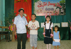 Đồng chí Quách Tùng Dương, Chủ tịch UBND TP. Hòa Bình tặng quà cho các học sinh nghèo vượt khó.