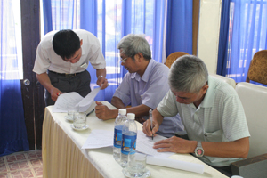 Cán bộ Phòng LĐ-TB&XH thành phố Hoà Bình hướng dẫn thân nhân người lao động xuất khẩu Hàn Quốc trên địa bàn ký cam kết về nước đúng thời hạn. Ảnh: Hương Lan