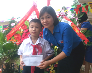 Đại diện chi đoàn Báo Hòa Bình trao học bổng cho em Nguyễn Văn Hiếu, trường tiểu học Kim Đồng, phường Tân Hòa (TP Hòa Bình).