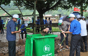 Lãnh đạo các sở, ngành tham gia dọn rác thải tại khu vực trước sân vận động huyện.