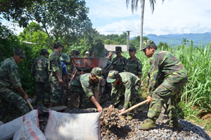 Lực lượng DBĐV huyện Tân Lạc gắn công tác huấn luyện với giúp nhân dân xóm Đon, xã Mỹ Hòa làm đường giao thông nông thôn.
