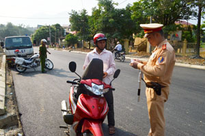 CSGT (Công an huyện Đà Bắc) kiểm tra giấy tờ người điều khiển xe máy tham gia giao thông.