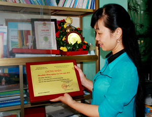 Chị Phùng Thị Lan giới thiệu giấy chứng nhận sản phẩm nông nghiệp tiêu biểu năm 2014 cho sản phẩm rau hữu cơ Lương Sơn.