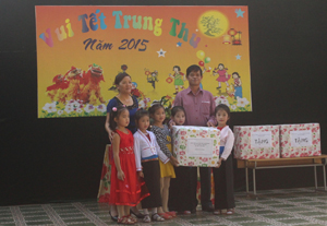 Đại diện huyện Tân Lạc trao quà cho trẻ em tại xã Đông Lai.